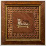 A 19th century petit point woolwork picture of a cat: seated on a tasseled cushion,