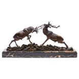 After Irenee Rochard (1906-1984) A bronze study of rutting stags on a rocky plinth,