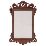 An 18th Century mahogany and partly gilt fret cut mirror:, with Ho-ho bird and shaped cresting,
