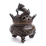 A Japanese bronze koro and cover: the pierced shallow domed lid surmounted with a dragon,