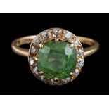 A green sapphire and diamond circular cluster ring: the cushion-shaped green sapphire approximately