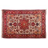 A Meshed rug:, the beige cartouche field with a central red geometric shaped pole medallion,