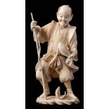 A Japanese carved ivory figure of a fisherman: wearing traditional costume with fishing pole in one