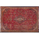 An Iranian carpet:, the red field with a central indigo lozenge pole medallion,