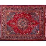 An Tabriz carpet:, the red cartouche field with a central indigo,