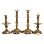 Two 18th century Continental brass candlesticks : with slender nozzles and wide circular drip trays