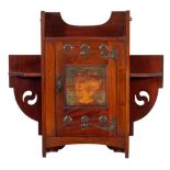 Shapland and Petter A mahogany and oxidised metal mounted wall cabinet:, of shaped outline,