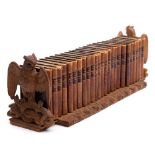A Black Forest carved linden wood extending book stand: the ends carved as owls with outstretched