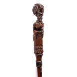 A carved hardwood walking stick: the handle in the form of a lady in a long dress,