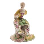 A Derby figure of a seated lady: wearing a puce trimmed yellow bodice,