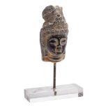 An Indo Persian carved stone head: wearing a traditional headdress, the head 14cm. high.