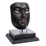 An Egyptian bronze mask: mounted on a stepped ebonised wood base, the mask 16.5cm.