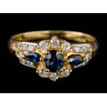 A sapphire and diamond cluster ring: set with oval and marquise-shaped sapphires and round,