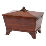 A William IV mahogany sarcophagus-shaped cellarette: the hinged top with carved acanthus and fruit