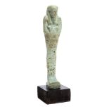 A late dynasty Egyptian shabti: of traditional design with impressed hieroglyphics to the body,