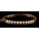 A 19th Century gold and split-pearl mounted hinged bangle: approximately 57mm inside diameter,