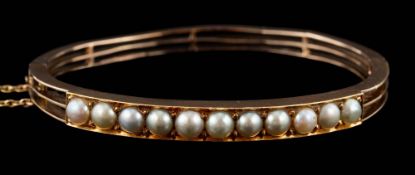 A 19th Century gold and split-pearl mounted hinged bangle: approximately 57mm inside diameter,