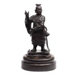 A Chinese bronze standing figure of a deity: wearing traditional costume on a naturalistic base,