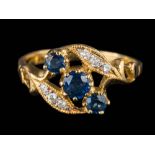 A sapphire and diamond nine-stone cross-over ring: the shank stamped '18K', ring size N.
