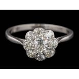 A platinum and diamond circular cluster ring: with central round old,