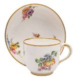 A Sèvres cup and saucer: painted with floral sprays within gilt dentil borders,