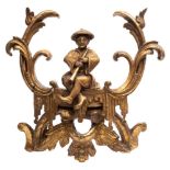 An 18th Century giltwood chinoiserie pediment: with arching foliate scrolls enclosing a seated