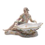 A Meissen figural sweetmeat dish: the seated gallant wearing a pink floral yellow ground jacket,