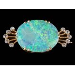 An opal and diamond brooch: the central, oval opal approximately 19mm long x 15mm wide x 3mm deep,