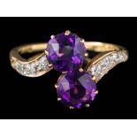 An amethyst and diamond two-stone cross-over ring: set with round amethysts each approximately 6.