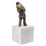 An Art Deco bronze and ivory figure of a young boy: dressed in a clown's suit, lighting a cigarette,