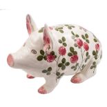 A large Plichta pottery pig money box: modelled in seated position and painted with flowering