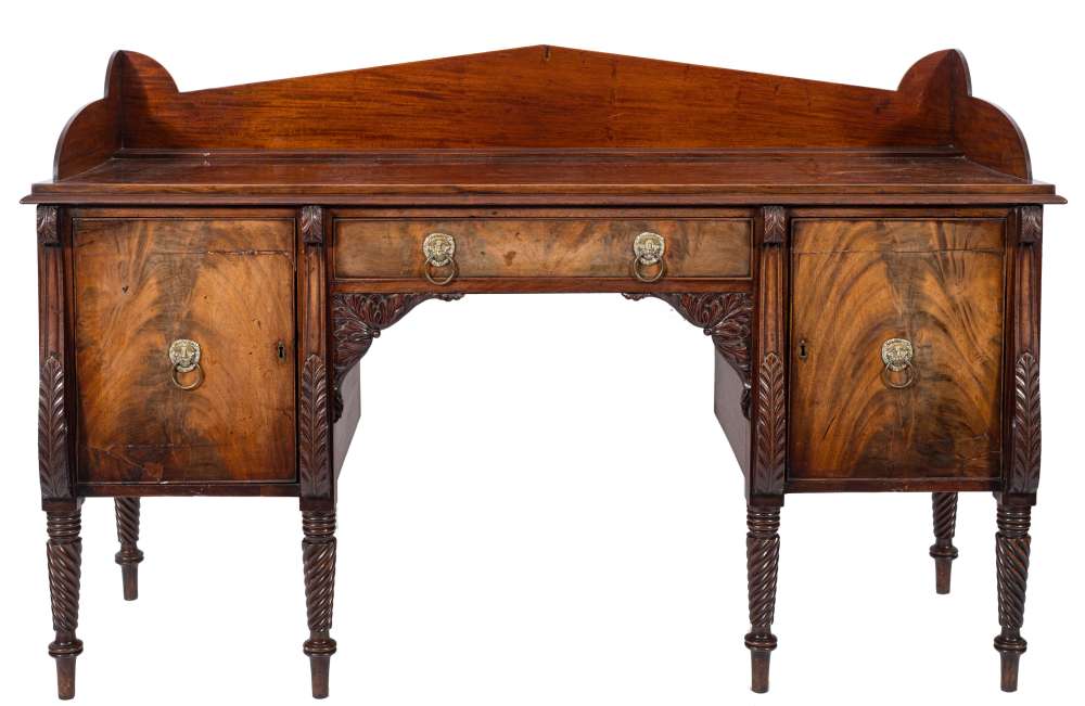 A Regency Scottish carved mahogany sideboard:, with an angled arch three quarter ledge back,