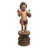 A polychrome wood figure of St John The Baptist as a boy: semi robed holding an orb in his left