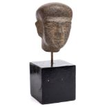 An Egyptian carved hardstone head: mounted on a square plinth base, the head 12cm. high.