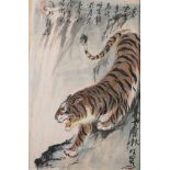 A Chinese painting of a tiger, signed Xiao-bai: the animal crouching on a steep bank,