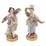A pair of Meissen figures: of a dancing youth and girl holding elaborate floral garlands,