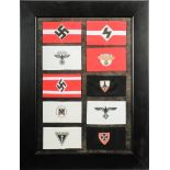 A framed collection of reproduction German army armbands: