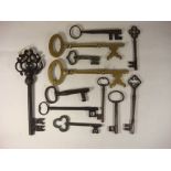 A collection of eleven antique brass, iron and steel keys and a brass key shaped corkscrew.: (12).