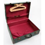 An American travelling trunk: green with brown border, red silk fitted interior with hangers.