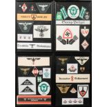A framed collection of reproduction German arm bands and cloth badges.