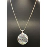 A circular silver pendant set with paua shell on a 28" silver curb chain.