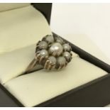 A vintage 9ct gold pearl dress ring. A central pearl surrounded by 8 smaller pearls.