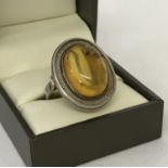 A modern design oval ring set with an amber cabochon.