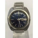 A men's Seiko automatic wristwatch with blue face and stainless steel bracelet.