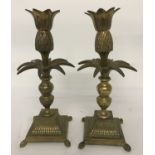 A pair of vintage brass candlesticks raised on 4 feet, with turned pedestal & pineapple decoration.