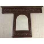 A vintage carved wooden panel with mirror inset.