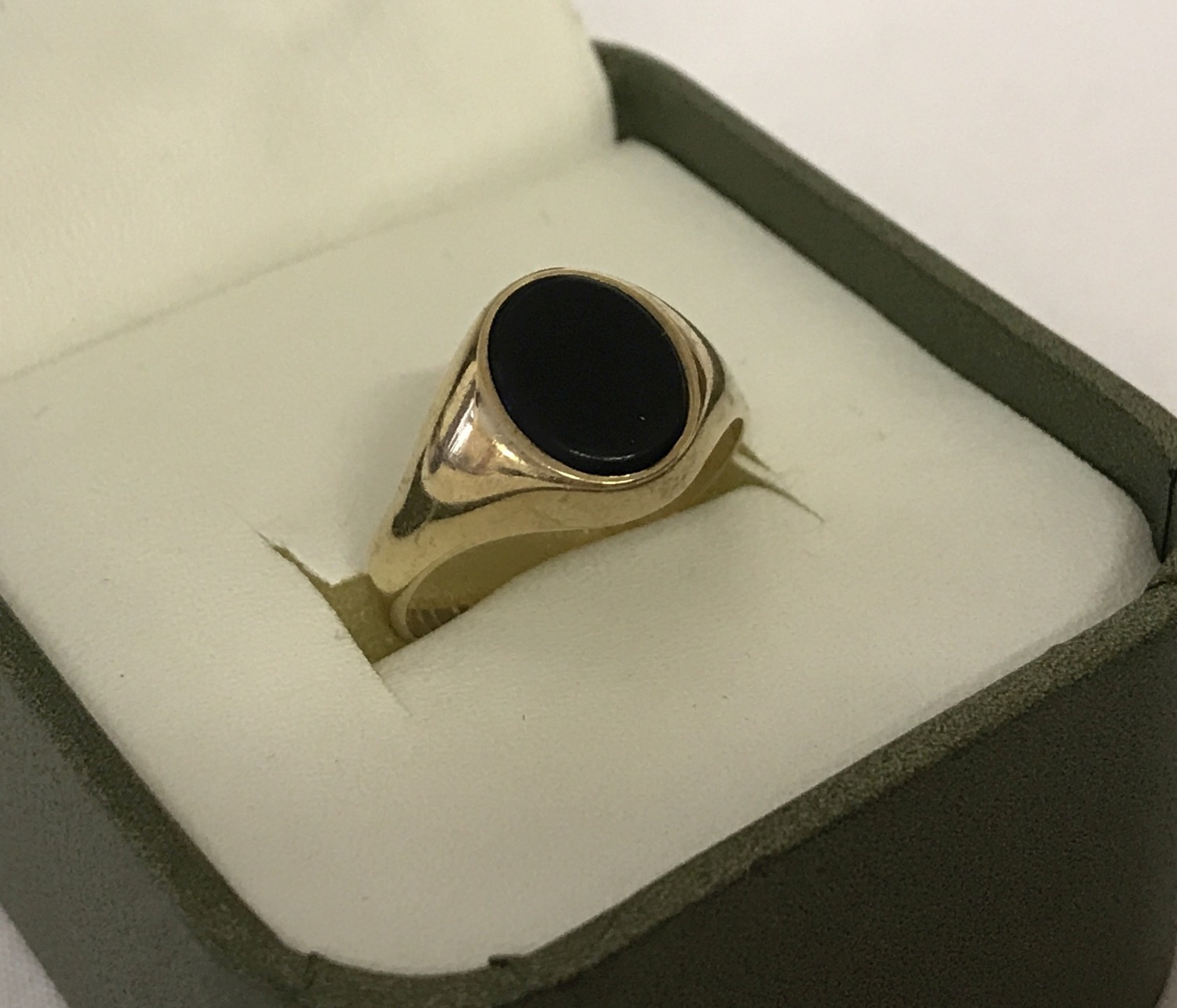 A 9ct gold signet ring set with an oval cut black onyx stone.