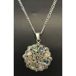 A flower design silver pendant set with oval and round cut paua shell. On a silver 20" figaro chain.