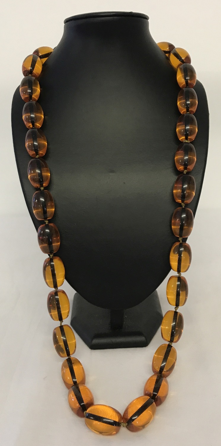 A 34" beaded necklace with large oval shaped amber style beads.