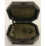 A wooden cased, brass octagonal shaped sundial compass, marked Gilbert & Sons.